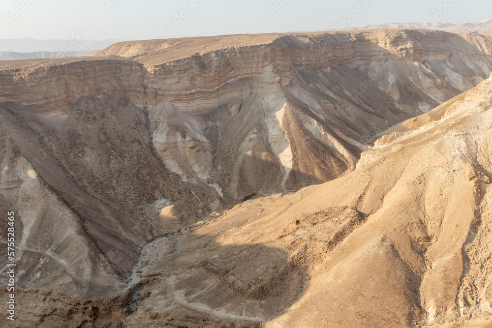View  during sunrise from the ruins of the fortress wall of the fortress of Masada to the adjoining gorge, in southern Israel