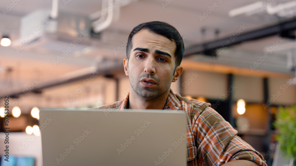 An American male teacher uses a laptop computer to chat with a friend. to be reviewing to prepare to teach students and in the library university operating area while waiting to enter the classroom An American male teacher uses a laptop computer to chat with a friend. to be reviewing to prepare to teach students and in the library university operating area while waiting to enter the classroom
