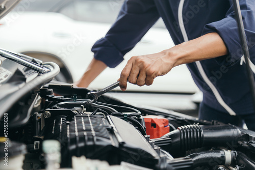 Automobile mechanic repairman hands repairing a car engine automotive workshop with a wrench, car service and maintenance,Repair service. © A Stockphoto