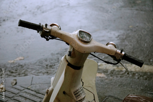 Vintage Honda Cub parked on the street under the rain