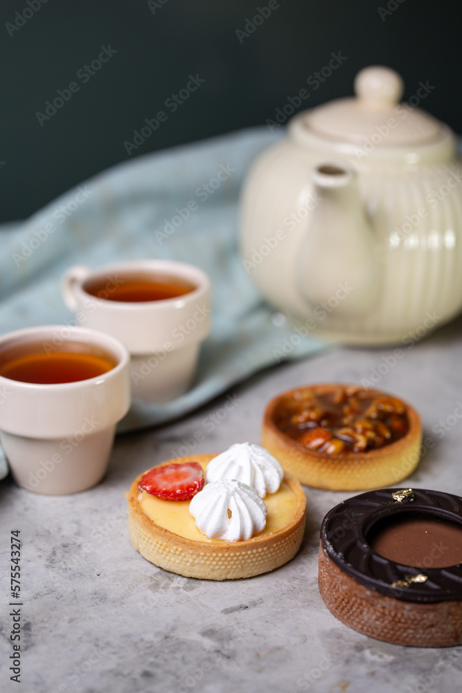 tartlets with fillings on the table. chchaynik , mugs and tartlets in the cafe tartlets with fillings on the table. chchaynik , mugs and tartlets in the cafe
