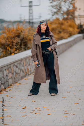 A woman walks outdoors in autumn, enjoys the autumn weather.