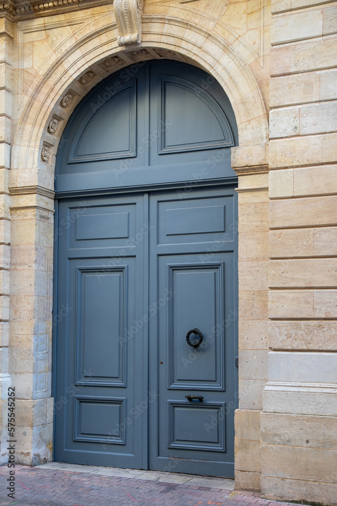 grey wooden high big arch door of street restored house entrance facade classic gate in city