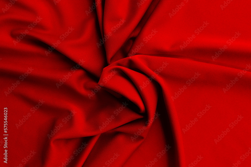 Thin bright knitted fabric lies twisted, top view. Thin bright knitted fabric lies twisted, top view.