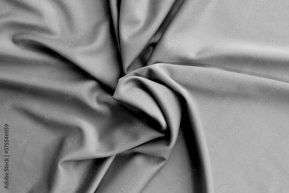 Thin bright knitted fabric lies twisted, top view. Thin bright knitted fabric lies twisted, top view.
