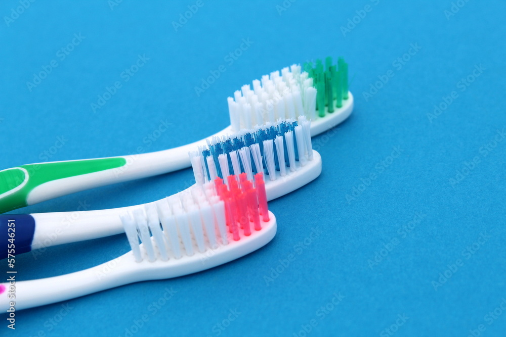 Three different toothbrushes lie on a blue background. Three different toothbrushes lie on a blue background.