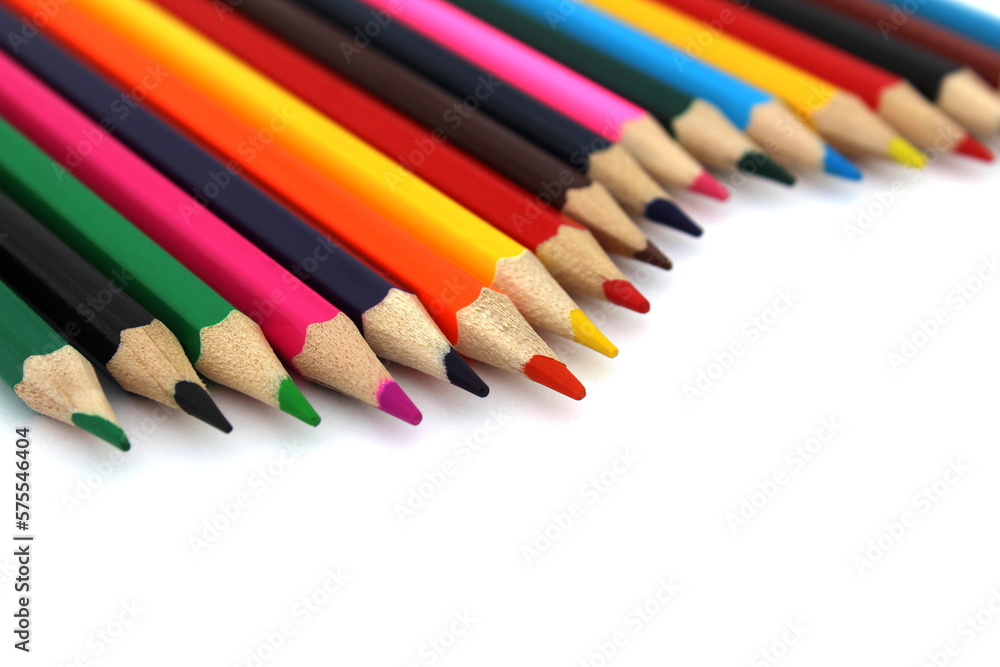 Bright colored pencils lie on a white background with space for text. Bright colored pencils lie on a white background with space for text.