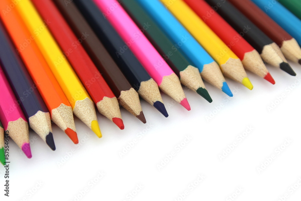 Bright colored pencils lie on a white background with space for text. Bright colored pencils lie on a white background with space for text.