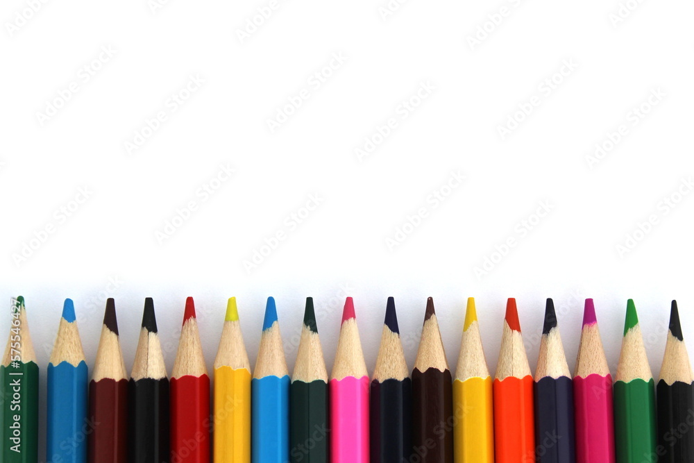 Bright colored pencils lie on a white background with space for text. Bright colored pencils lie on a white background with space for text.