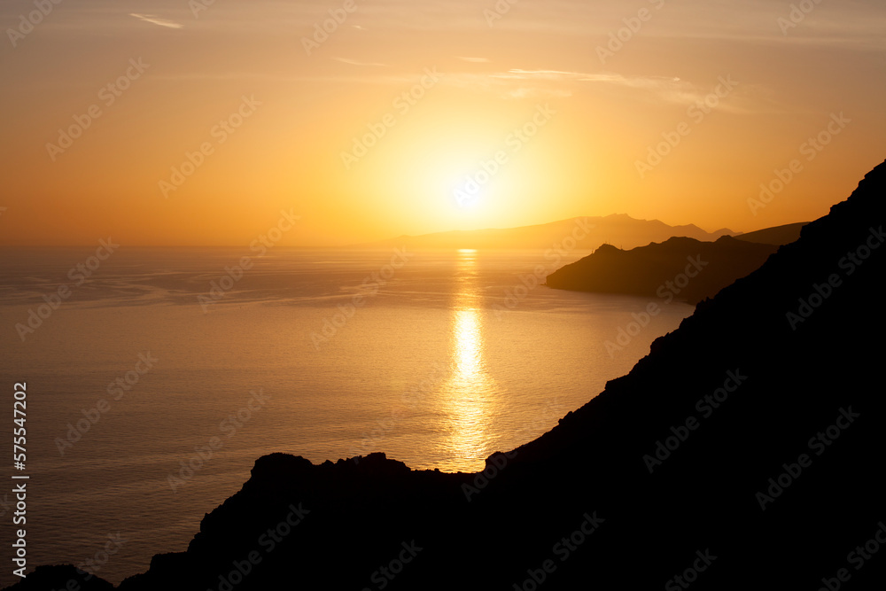 Golden sunset on the ocean with some cliff silhouette Golden sunset on the ocean with some cliff silhouette