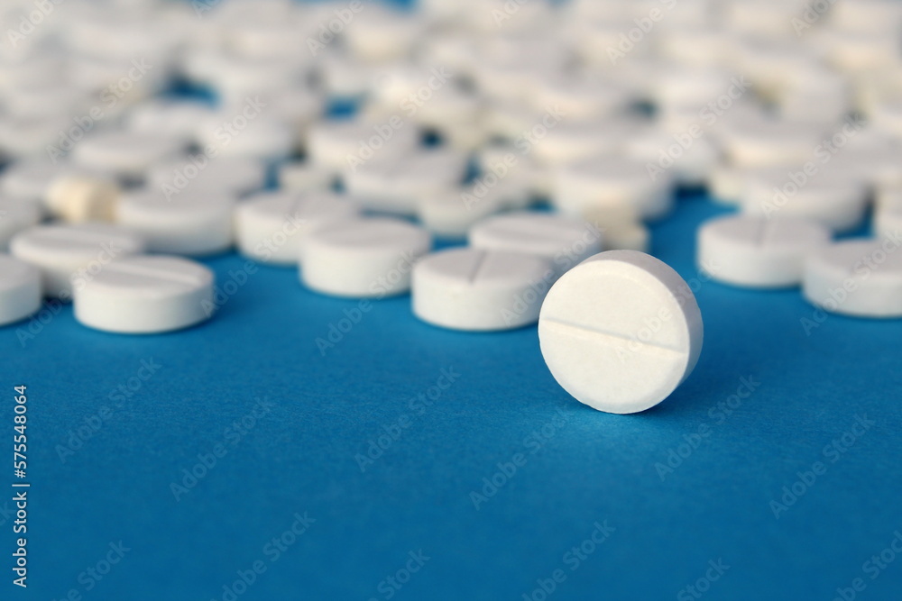 White pills lie on a gray background. White pills lie on a gray background.