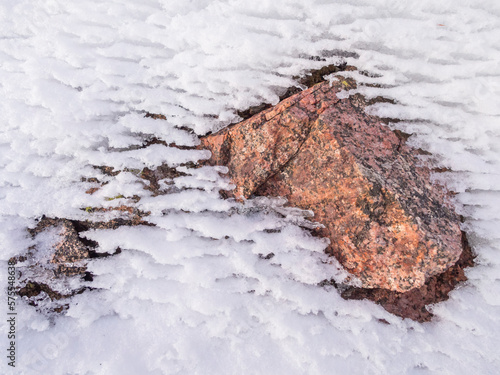 Pink granite protrudes through the snow in White River National Forest, Colorado.