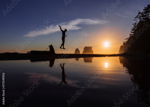 Slackliner walking over coastal water, La Push, Washington, USA