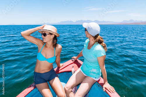 Two women sitting on panga boat on sea, Coronado Island, Baja California Sur, Mexico photo