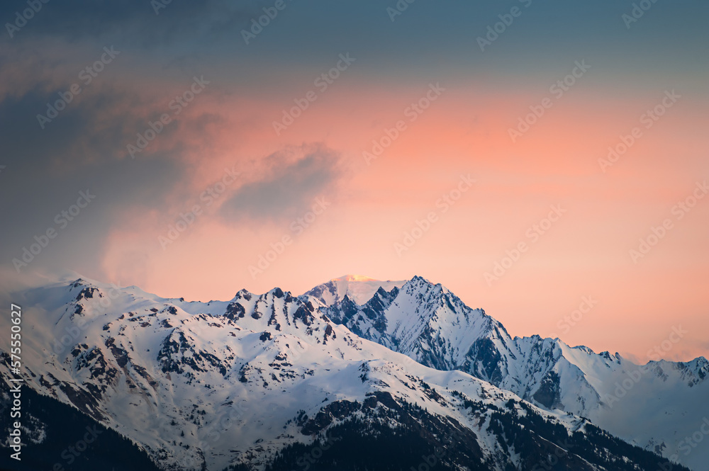 Snow-covered mountains and the pink sky at sunrise. Alps, France.