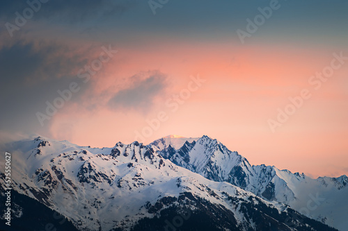 Snow-covered mountains and the pink sky at sunrise. Alps, France.
