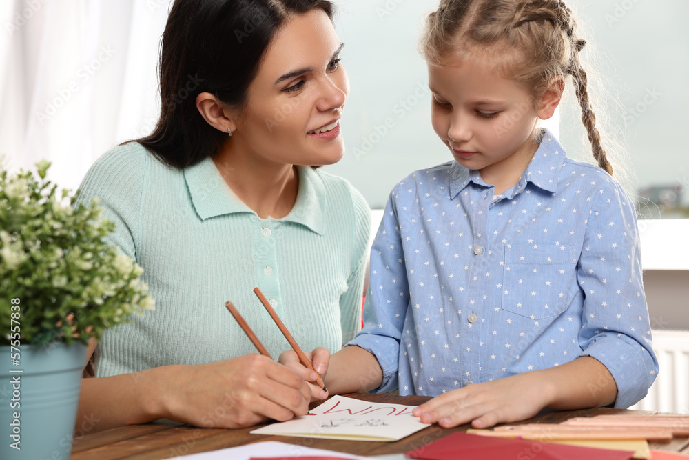 Cute little girl with her mother making beautiful greeting card at home Cute little girl with her mother making beautiful greeting card at home