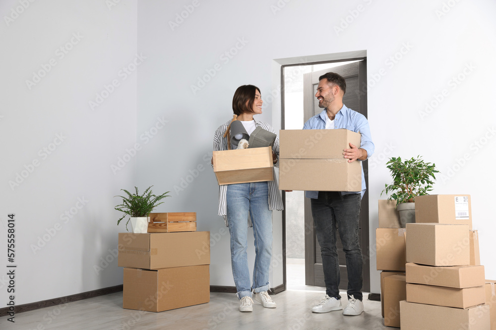 Happy couple with moving boxes entering in new apartment Happy couple with moving boxes entering in new apartment