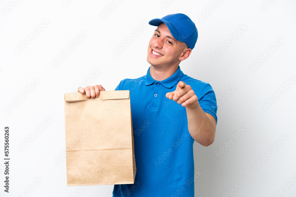 Young Brazilian man taking a bag of takeaway food isolated on white background pointing front with happy expression Young Brazilian man taking a bag of takeaway food isolated on white background pointing front with happy expression