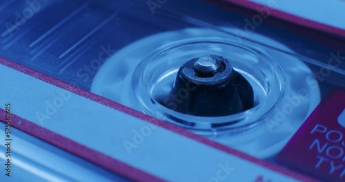 Close-Up Of Cassette Tape Reel Turning In Blue Light