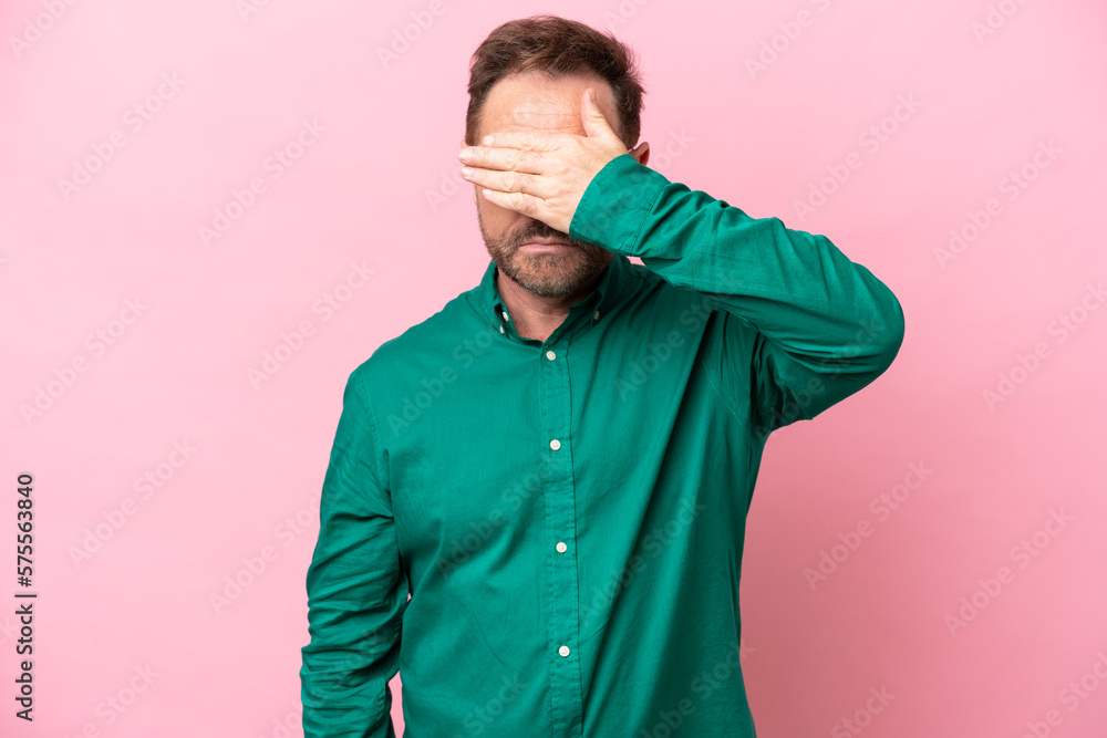 Middle age caucasian man isolated on pink background covering eyes by hands. Do not want to see something