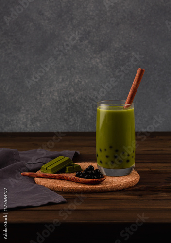 Matcha bubble tea with matcha chocolate and tapioka pearls on a dark background. photo