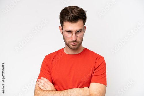 Young caucasian man isolated on white background With glasses and arms crossed