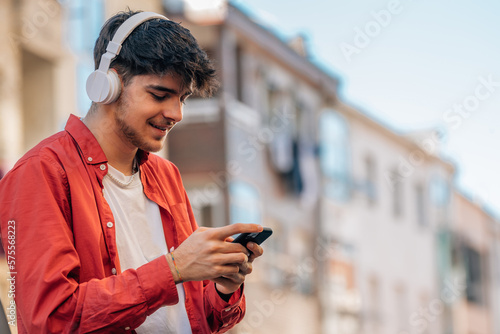 young man with headphones and mobile phone photo