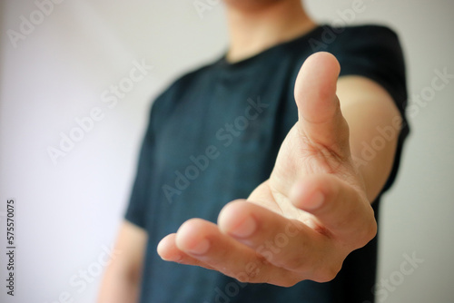 Opened hand giving some help. Young male offering helping hand. Banner with gesture photo.
