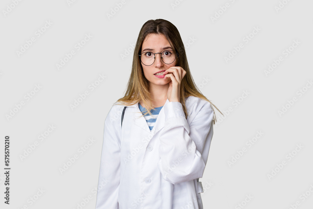 Compassionate female physician with a stethoscope around her neck, ready to diagnose and care for her patients in her signature white coat biting fingernails, nervous and very anxious. Compassionate female physician with a stethoscope around her neck, ready to diagnose and care for her patients in her signature white coat biting fingernails, nervous and very anxious.