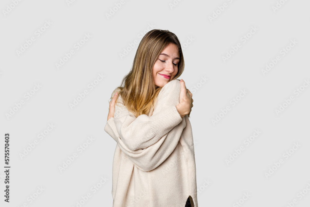 Young blonde posing for a portrait isolated, exuding natural beauty and radiance hugs, smiling carefree and happy. Young blonde posing for a portrait isolated, exuding natural beauty and radiance hugs, smiling carefree and happy.