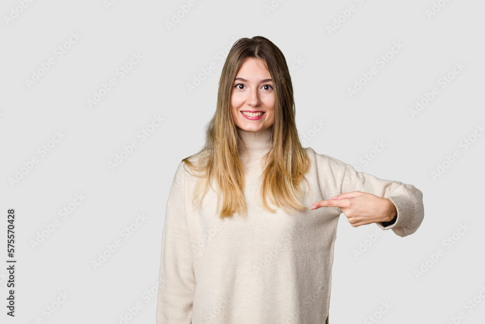 Young blonde posing for a portrait isolated, exuding natural beauty and radiance person pointing by hand to a shirt copy space, proud and confident Young blonde posing for a portrait isolated, exuding natural beauty and radiance person pointing by hand to a shirt copy space, proud and confident