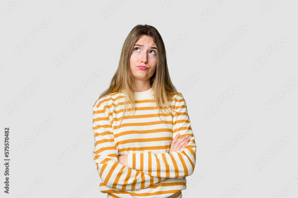 Young blonde posing for a portrait isolated, exuding natural beauty and radiance tired of a repetitive task. Young blonde posing for a portrait isolated, exuding natural beauty and radiance tired of a repetitive task.