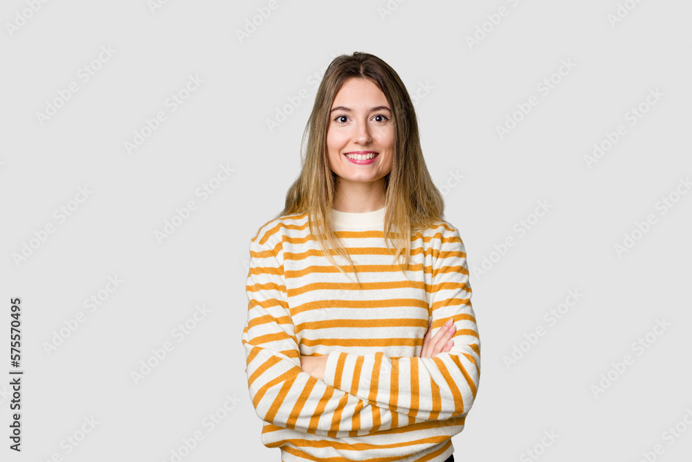 Young blonde posing for a portrait isolated, exuding natural beauty and radiance who feels confident, crossing arms with determination. Young blonde posing for a portrait isolated, exuding natural beauty and radiance who feels confident, crossing arms with determination.