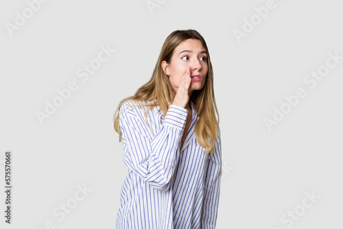 Young blonde posing for a portrait isolated, exuding natural beauty and radiance being shocked because of something she has seen.