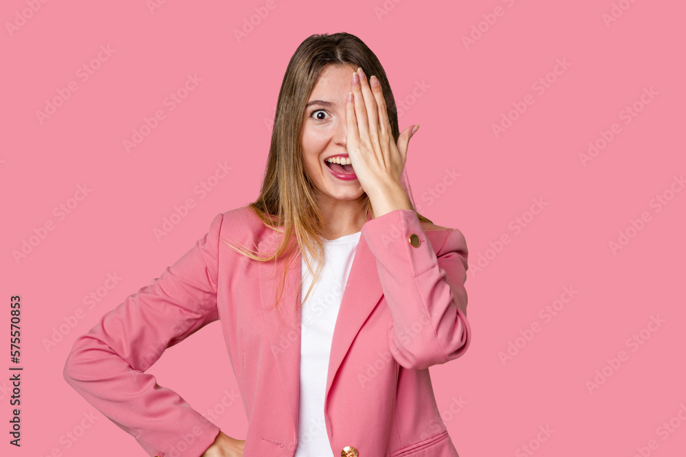 Young blonde posing for a portrait isolated, exuding natural beauty and radiance having fun covering half of face with palm. Young blonde posing for a portrait isolated, exuding natural beauty and radiance having fun covering half of face with palm.