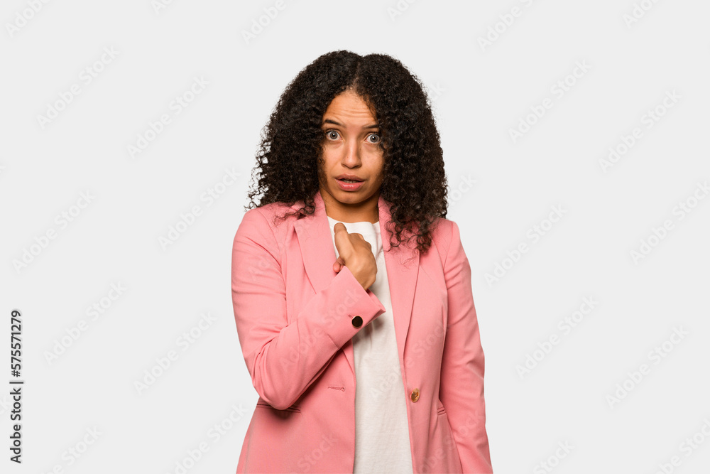 Young african american curly woman isolated surprised pointing with finger, smiling broadly. Young african american curly woman isolated surprised pointing with finger, smiling broadly.