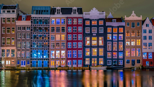 Photography colorful street with houses at the Damrak in Amsterdam, they call it the dancing