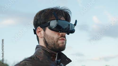Man pilot a drone with technologic virtual reality glasses and remote controller