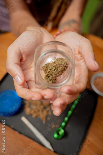 Hippie style woman examines joints and buds of medical marijuana.