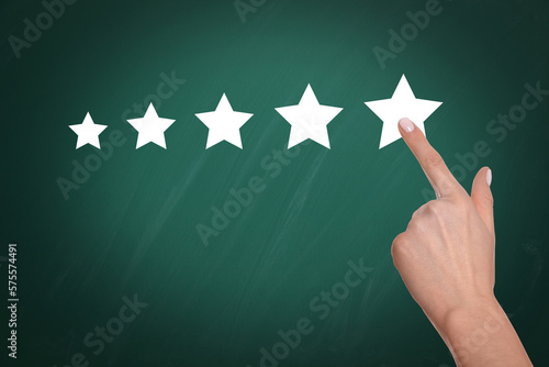 Quality rating. Woman pointing at stars on chalkboard, closeup