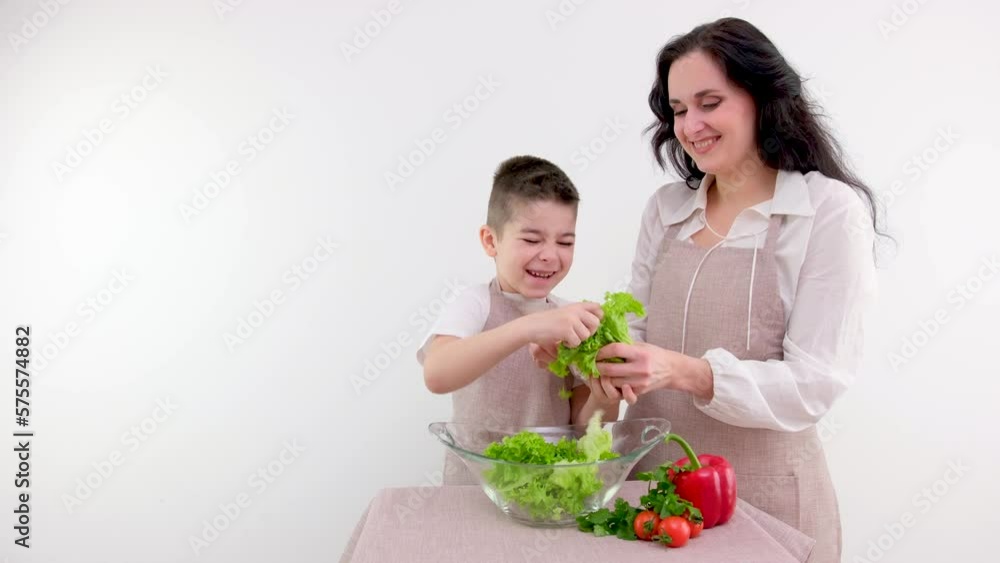 mother and son preparing salad with hands tearing Lettuce leaves white background space for text teach child to cook delicious healthy food vitamins vegetables vegetarianism benefit woman and boy mother and son preparing salad with hands tearing Lettuce leaves white background space for text teach child to cook delicious healthy food vitamins vegetables vegetarianism benefit woman and boy