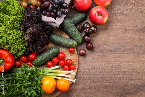 Different fresh ripe vegetables and fruits on wooden table, flat lay. Space for text