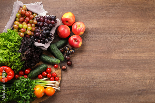 Different fresh ripe vegetables and fruits on wooden table, flat lay. Space for text