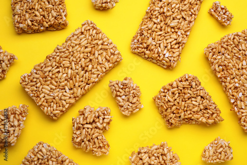 Puffed rice bars (kozinaki) on yellow background, flat lay
