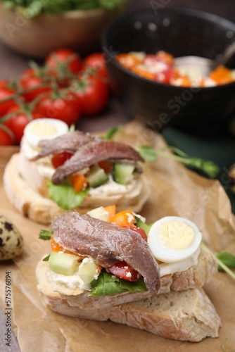 Delicious bruschettas with anchovies, eggs, cream cheese, tomatoes, bell peppers and cucumbers on table