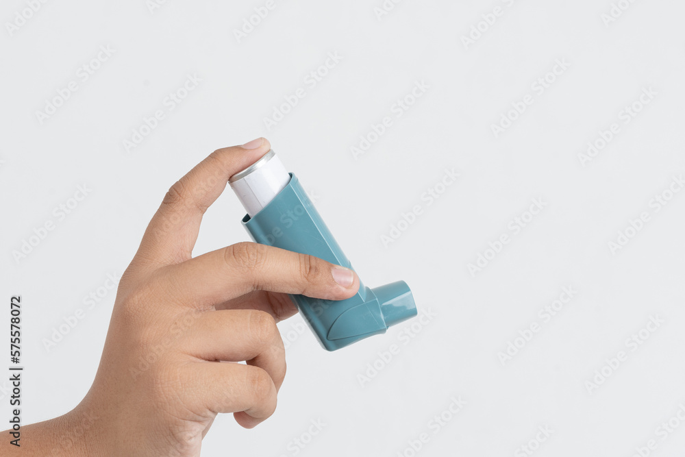 Asian boy hand holding asthma inhaler on white background with space for text Asian boy hand holding asthma inhaler on white background with space for text