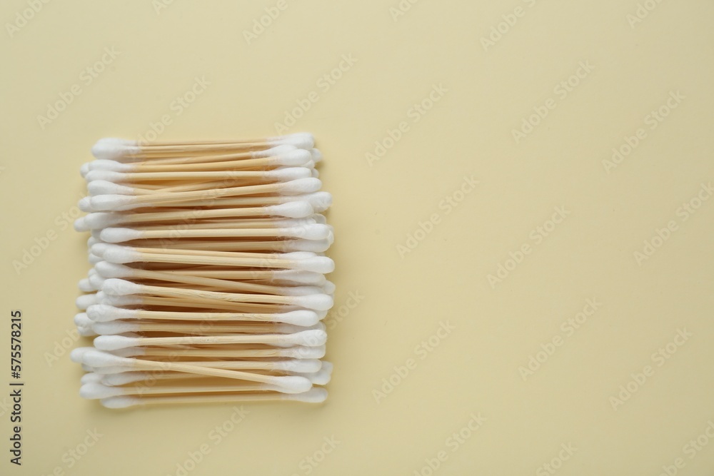 Many wooden cotton buds on beige background, flat lay. Space for text Many wooden cotton buds on beige background, flat lay. Space for text