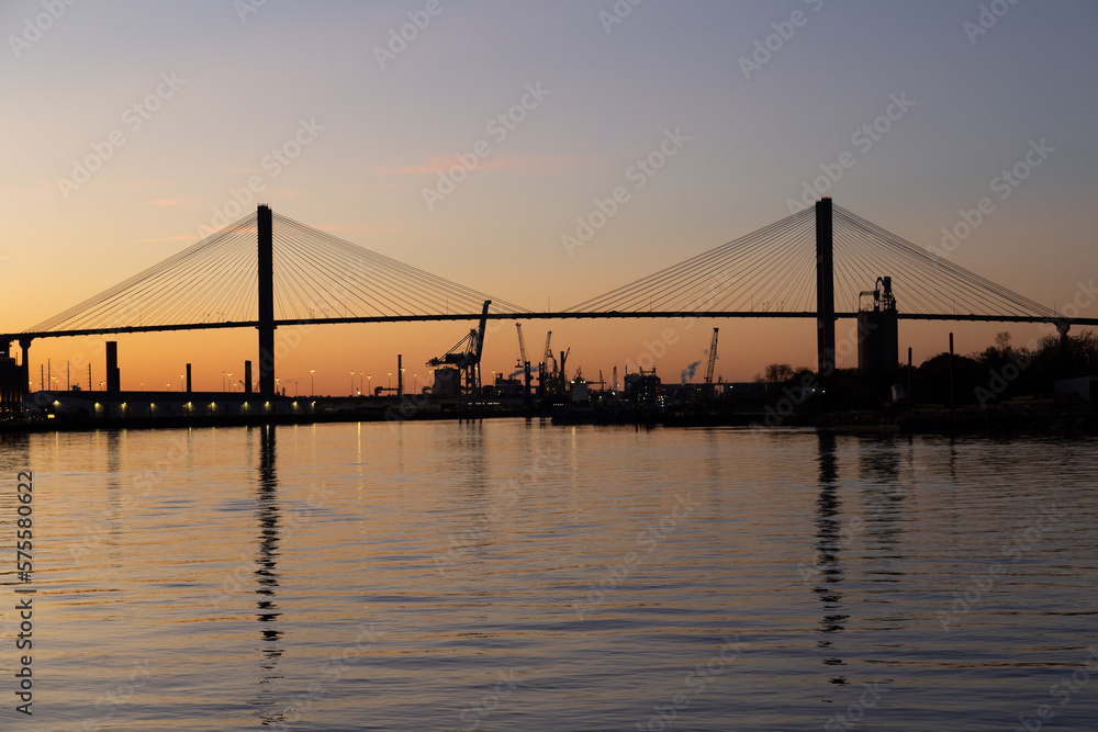 Fototapeta premium The 1991 cable-stayed Talmadge Memorial Bridge over the Savannah River seen in silhouette during a golden hour sunset