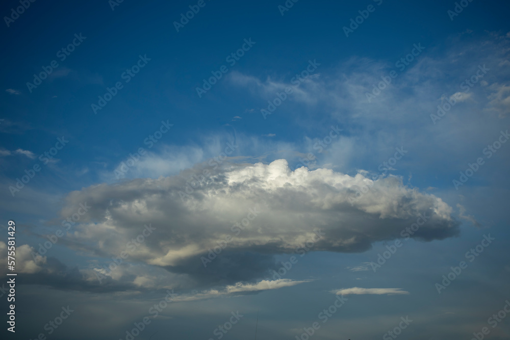 Obraz premium Intense blue sky with fluffy white and greyish storm clouds in the middle and intense midday light